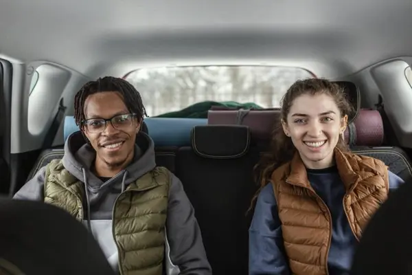 Pareja viajando en carro compartido promoviendo carpooling y movilidad sostenible para empresas en Colombia